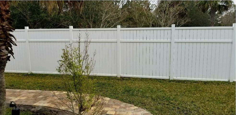 The same vinyl fence after cleaning, an even white from the ground to the top rail.