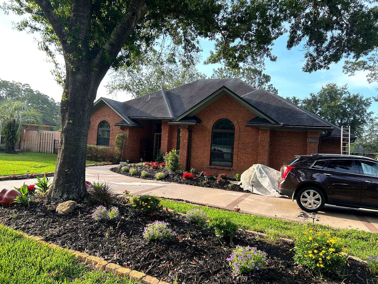 A brick home in Jacksonville with its concrete driveway stained dark and patchy.